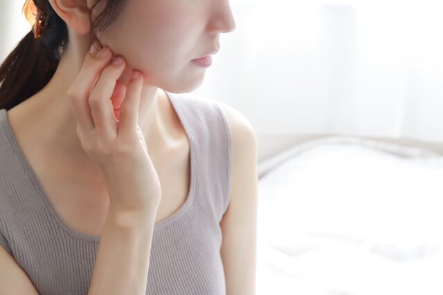 顎に手をあてる女性